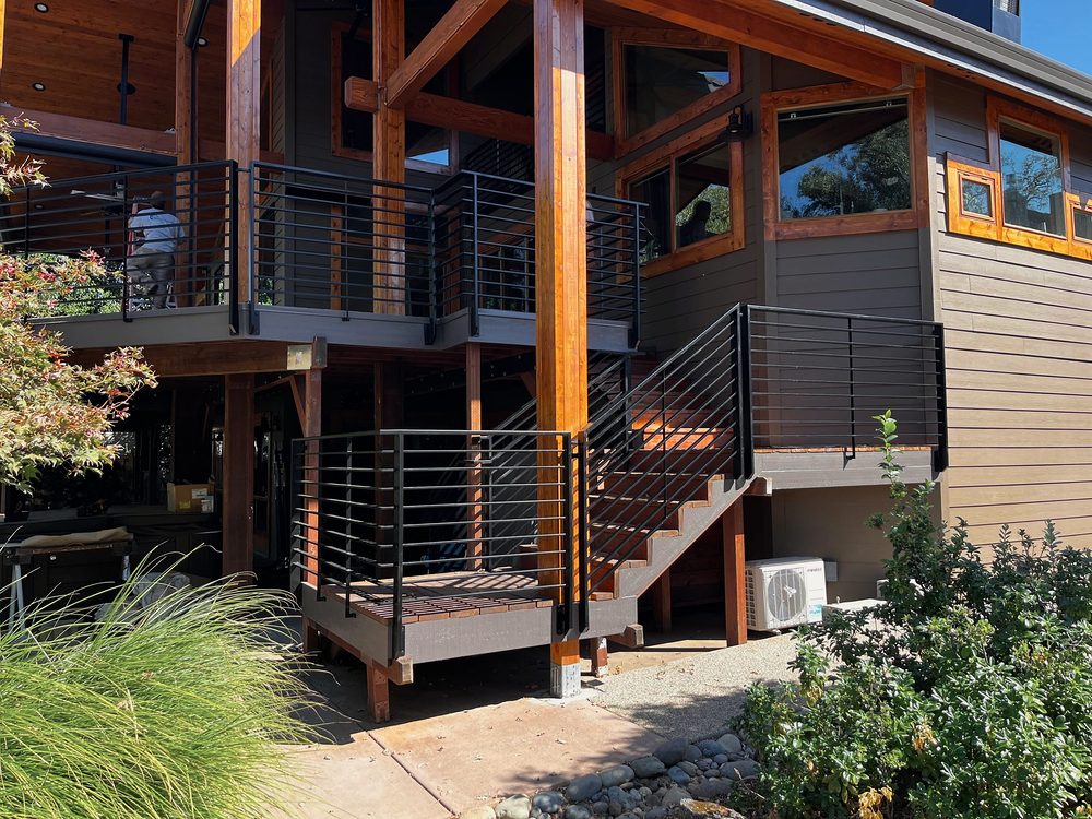 Black steel horizontal bar railings on a two level deck and stair