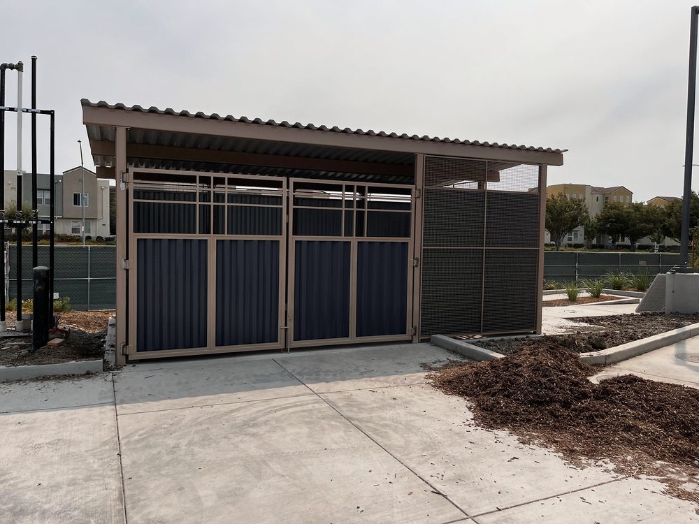 Steel enclosure with roof and panel gates at a commercial site