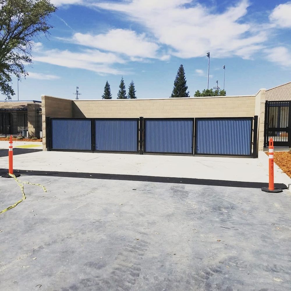 Steel framed gates with corrugated panels across a wide opening